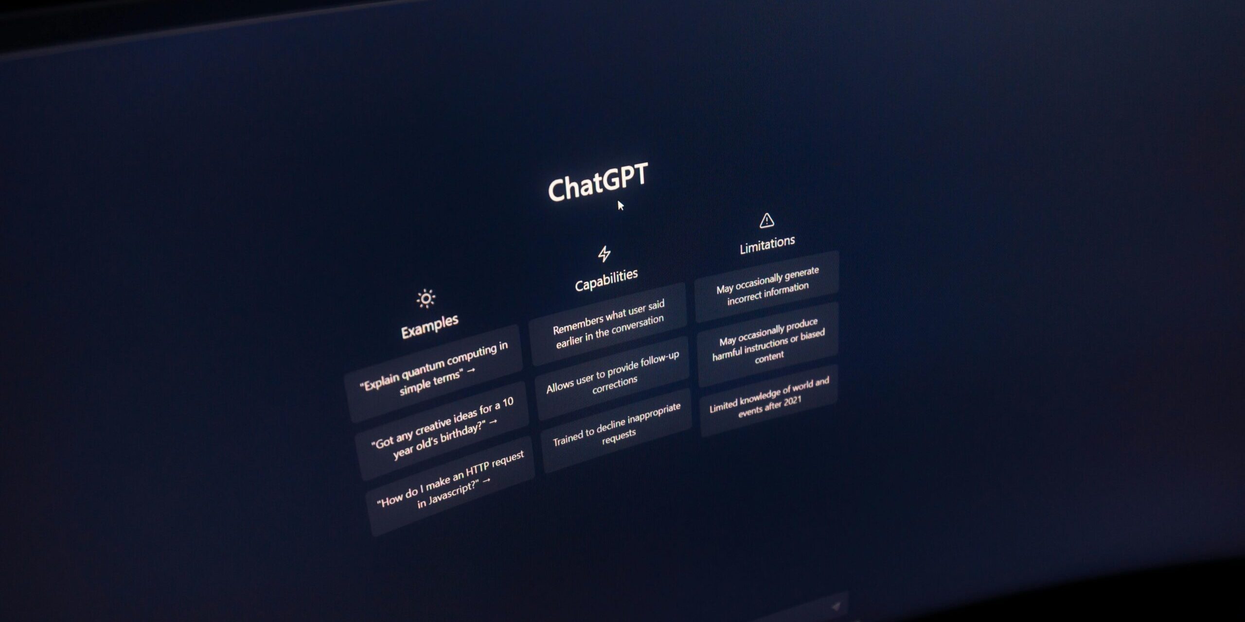 Close-up of a computer screen displaying ChatGPT interface in a dark setting.