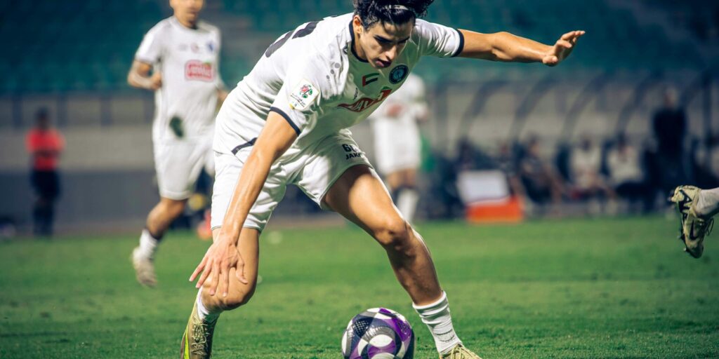 Energetic soccer player in intense match, demonstrating skill and agility.